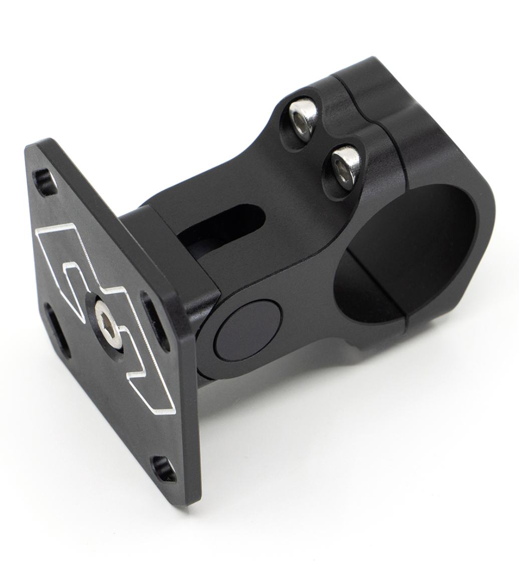 The image shows the DMD 28mm AMPS Bracket SE, a specialized aluminum mounting bracket with minimal visible screws and an adjustable AMPS plate. The bracket features decorative carvings and is designed to attach to a 28mm bar, extending 3.3 cm to the AMPS plate surface.