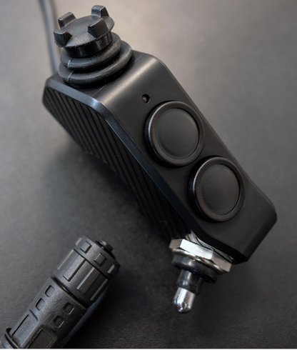 Shows DMD Remote front side with 360° Joystick two buttons and switch and end of connector cable